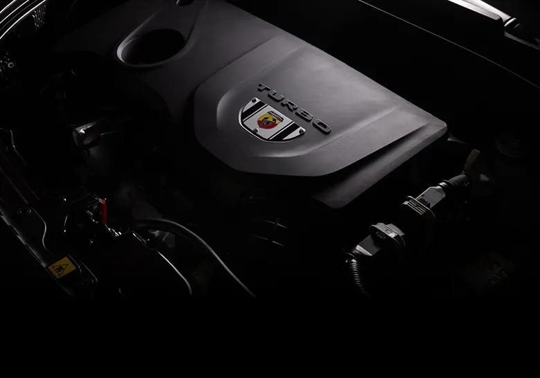 Zoom no motor de Abarth, com 185 cv de potência. Há o emblema da marca acima do motor, abaixo da palavra "Turbo".