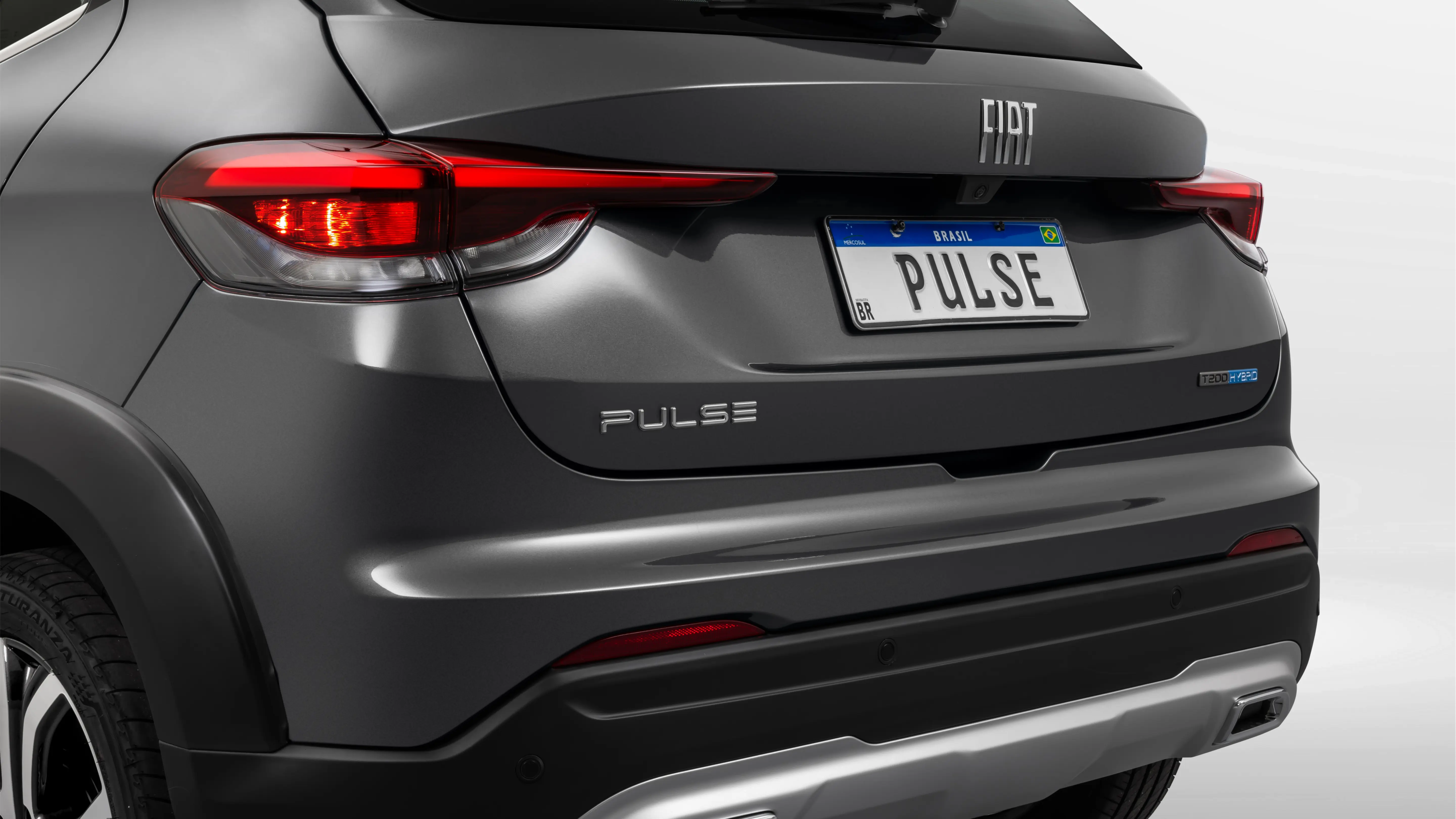 Traseira do Fiat Pulse na cor azul. Ele está com o porta-malas aberto e vazio.